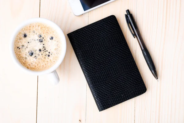 Smartphone with notebook and cup of strong coffee — Stock Photo, Image