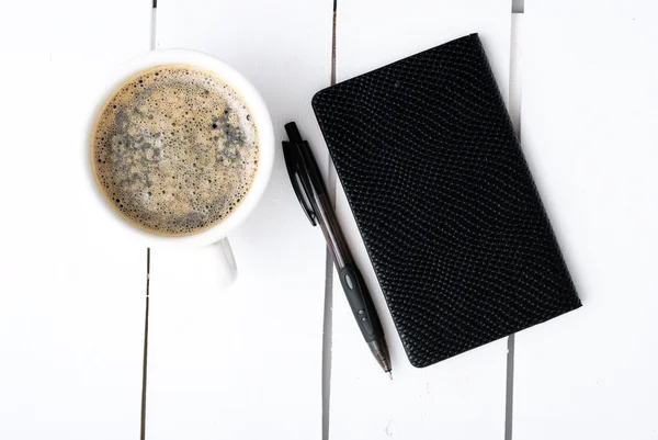 Smartphone with notebook and cup of strong coffee — Stock Photo, Image