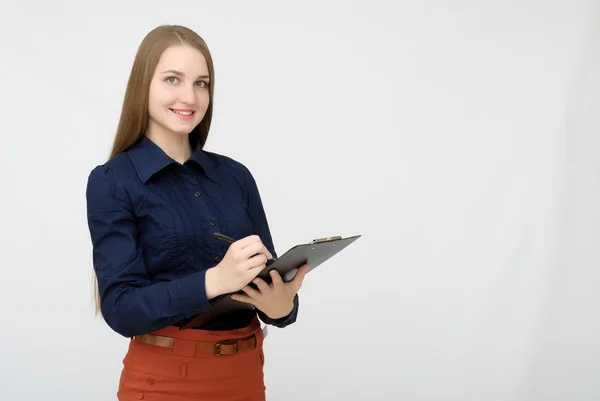 Portret van een lachende zakenvrouw met pen en papieren map. Jonge mooie arbeider schrijft iets in haar papieren. — Stockfoto