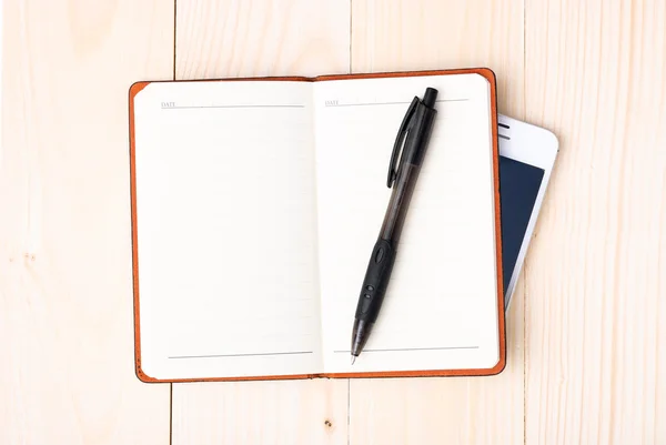 Kleine Kladblok met pen en smartphone — Stockfoto