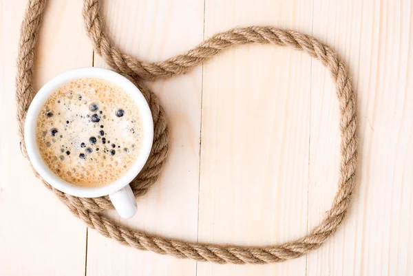 Tasse Kaffee mit Schaum auf Holztisch — Stockfoto