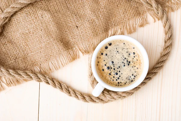 Чашка кави з піною на дерев'яному столі — стокове фото