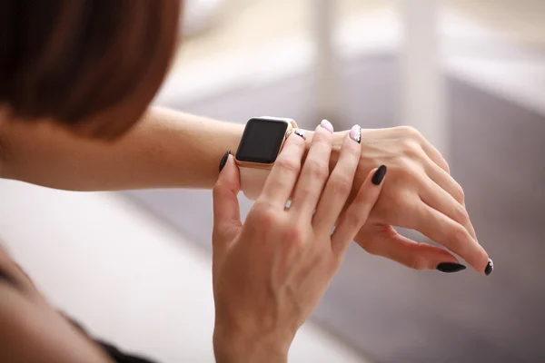 Using her smartwatch at home in the living room — Stock Photo, Image