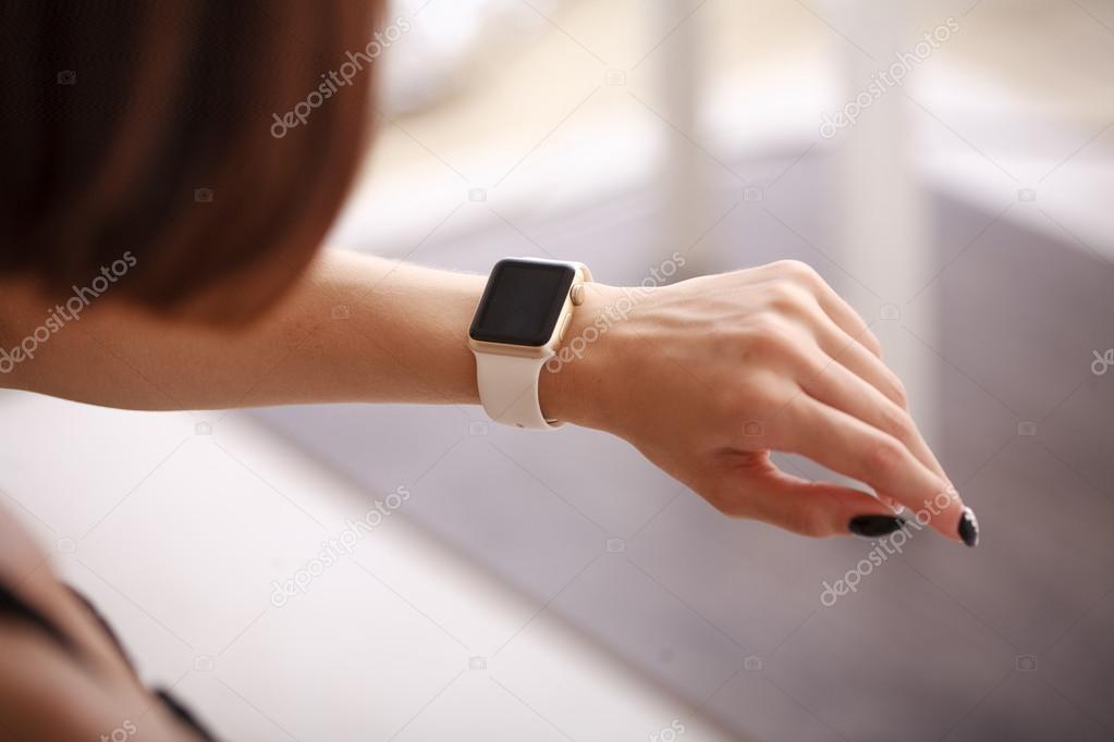 using her smartwatch at home in the living room