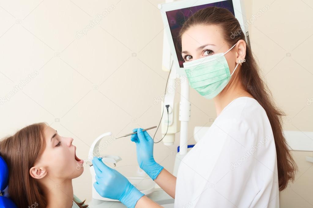 attractive woman dentist with girl patient