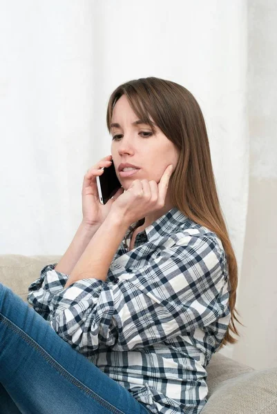 Portrait of young woman talking by phone indoor. — Stock Photo, Image