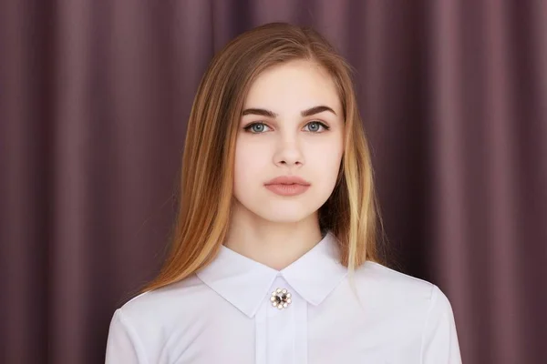 Office Girl in una camicetta bianca su uno sfondo di tende marroni — Foto Stock