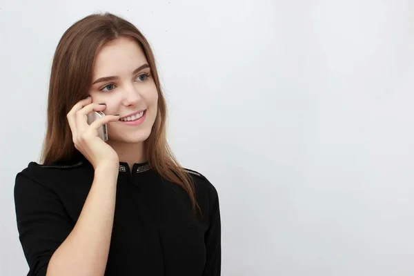 Beyaz bir arka plan üzerinde izole cep telefonuyla genç iş kadını — Stok fotoğraf