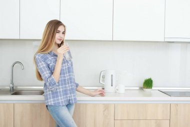 güzel bir genç kadın bir bardak su ile mutfak üzerinde tutar..