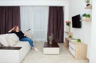 genç kadın kanepe evde TV izlerken.