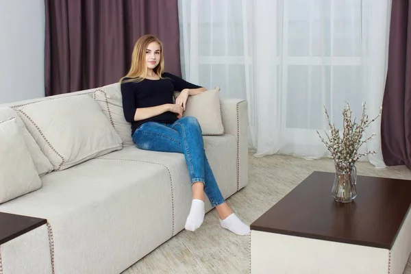ソファで家にテレビを見ている若い女性. — ストック写真