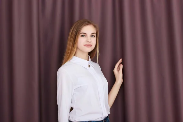 茶色のカーテンの背景に白のブラウスでのオフィスの女の子 — ストック写真