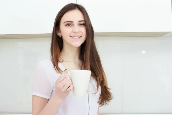 Junge Frau mit schwarzem Haar trinkt Kaffee in der Küche — Stockfoto