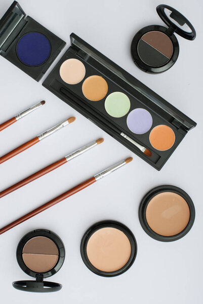 Кисть для макияжа и косметика на белом фоне