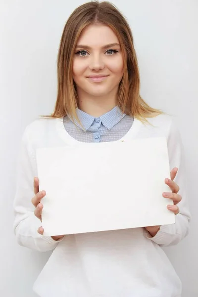 若い女性を空白のカードや紙を笑顔 — ストック写真