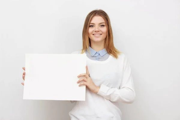 Junge lächelnde Frau zeigt leere Karte oder Papier — Stockfoto
