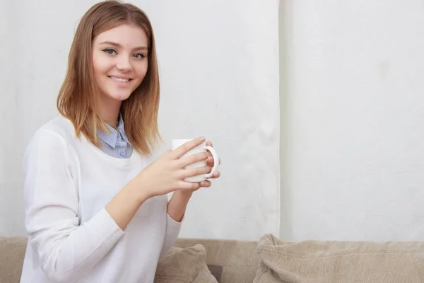 Donna seduta sul divano nel suo soggiorno e bere caffè — Foto Stock