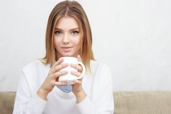 Frau sitzt auf Couch im Wohnzimmer und trinkt Kaffee — Stockfoto