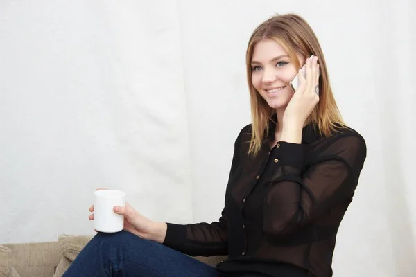 Retrato de una joven hablando por teléfono y tomando café — Foto de Stock