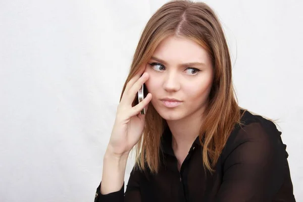 Portrait of young woman talking by phone indoor — Stock Photo, Image