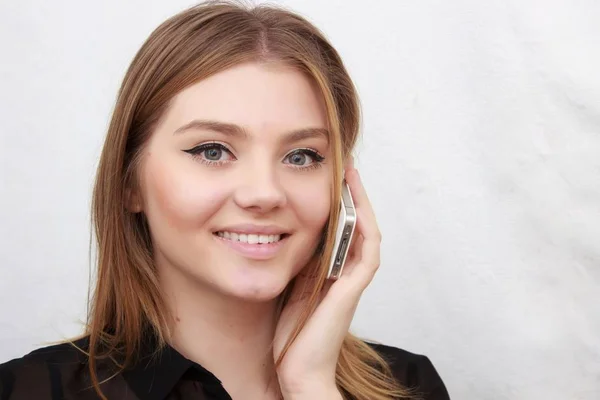 Portrait of young woman talking by phone indoor — Stock Photo, Image