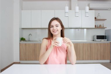 Gülümseyen kadın hangi kahve ile mutfak bakimi ve kameraya bakıyor