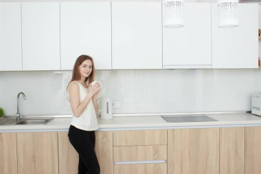 genç kadın mutfakta kahve içme beyaz bir T shirt