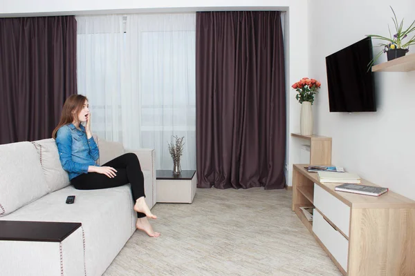 Tv izlerken bir mavi gömlek ve siyah pantolon genç kadın.