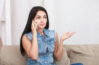 Güzel genç kadın kapalı cep telefonuyla konuşan