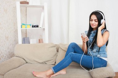 Dinlenme ve koltukta oturan kulaklık ile müzik dinlemek bir rahat kız