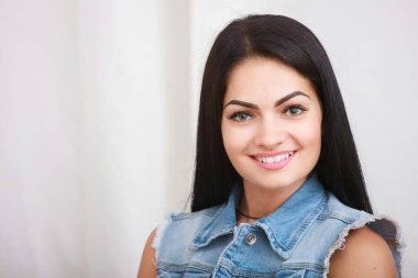 Gülümseyen ve kamera beyaz arka plan üzerinde seyir çekici genç kadın