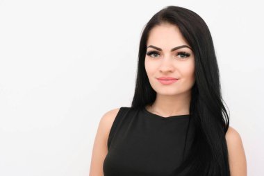 gülümseyen ve kameraya bakarak siyah elbiseli çekici genç kadın.