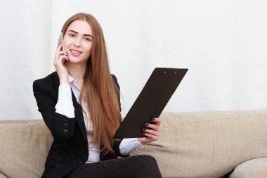 Güzel genç çekici kız kanepede oturan siyah saçlı