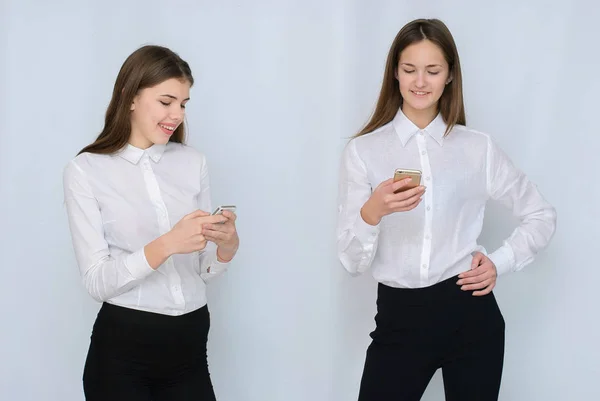 Two young girls use their mobile isolated — Stock Photo, Image