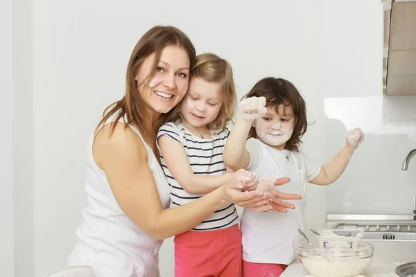 Madre con sus hijos de 5 años cocinando pastel de vacaciones en la cocina — Foto de Stock