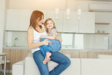 Sevgi dolu bir aile. Anne ve kızı oynuyorlar ve sarılıyorlar..