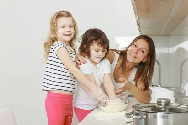 Madre con sus hijos de 5 años cocinando pastel de vacaciones en la cocina — Foto de Stock