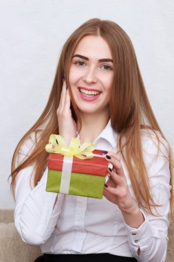 Beyaz arka plan üzerinde izole kozmetik şişe ile güzel genç gülümseyen kadın