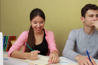 Mutlu arkadaş Kütüphane masada otururken dizüstü bilgisayar kullanarak. Grup çalışma Üniversitesi Kütüphanesi