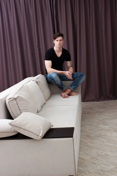 自宅のソファに座って休んでいるカジュアルな疲れた男の肖像 — ストック写真