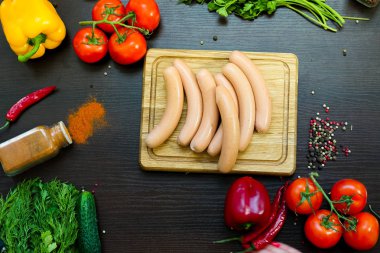 Sosis sebze ile düzenlenmiş kesme tahtası üzerinde