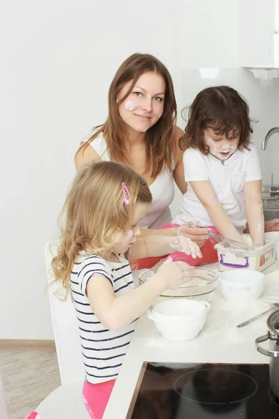 Madre con sus hijos de 5 años cocinando pastel de vacaciones en la cocina — Foto de Stock