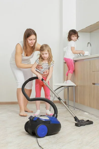 Little beautiful smiling girl running with vacuum cleaner at home. — Stock Photo, Image