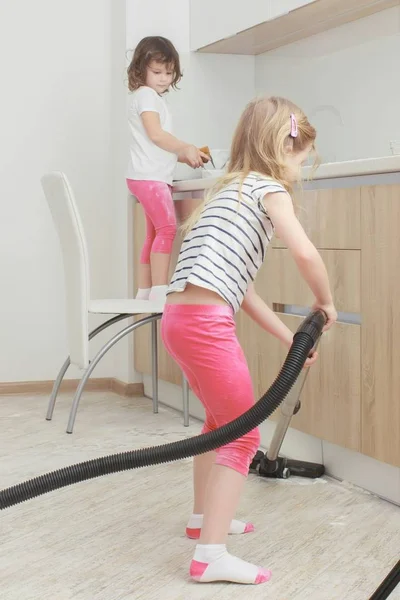 Pequena menina sorridente bonita correndo com aspirador de pó em casa . — Fotografia de Stock