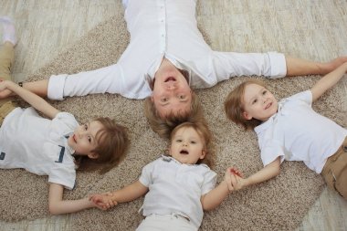 Bir yerde yatarken üç sevimli küçük oğlu ile genç Baba Üstten Görünüm