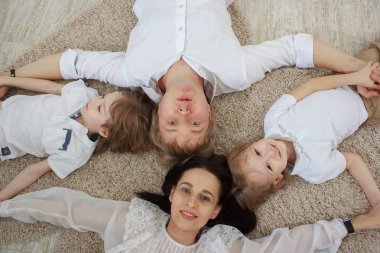 Güzel genç anne, yerde yatarken şirin küçük oğulları Üstten Görünüm