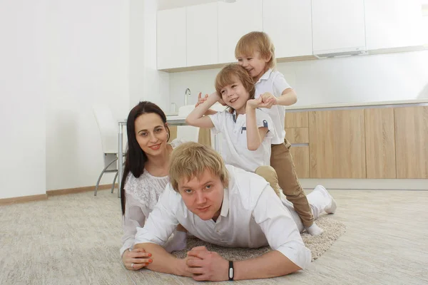 Felice famiglia madre, padre e figli che giocano e coccolano a casa — Foto Stock