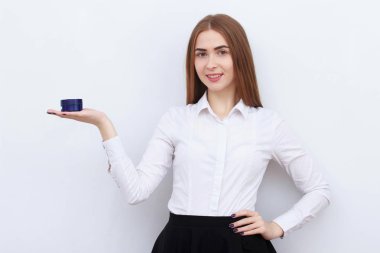 Beyaz arka plan üzerinde izole kozmetik şişe ile güzel genç gülümseyen kadın