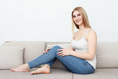 Güzel sarışın kız kanepede oturan