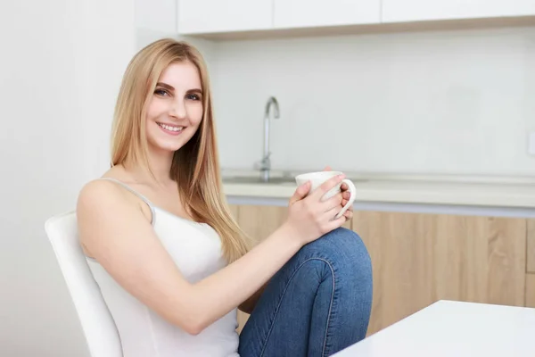 Junge Frau mit schwarzem Haar trinkt Kaffee in der Küche — Stockfoto
